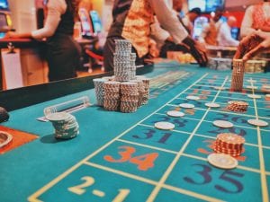 Gaming table with stacks of chips; image by Kay, via Unsplash.com.