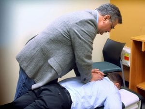 A chiropractor performs an adjustment on a patient