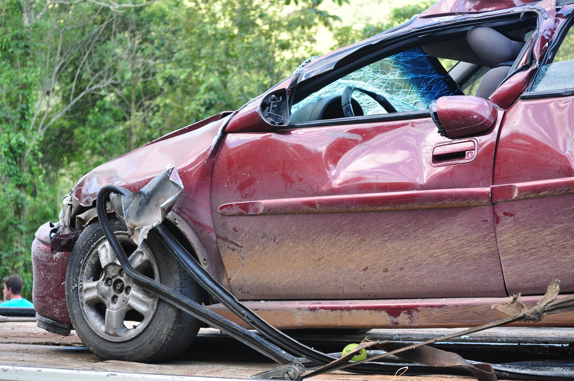Maroon car badly damaged in auto accident; image by NettoFiguiredo, via Pixabay.com.
