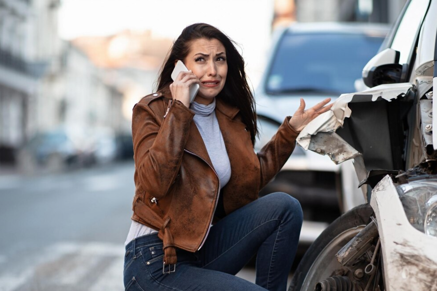 Woman on phone after car accident; image by Drazen Zigic, via Freepik.com.