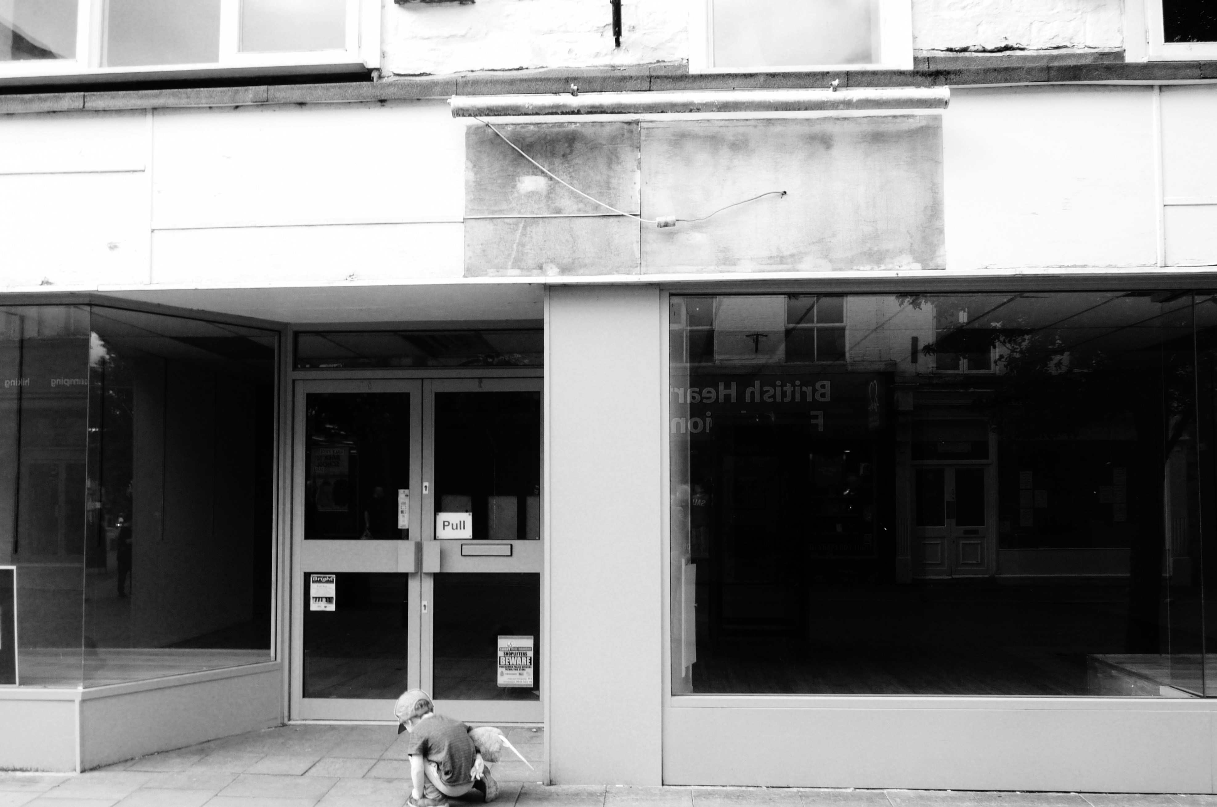 Child outside abandoned shop; image by Competitive Insight, via Unsplash.com.