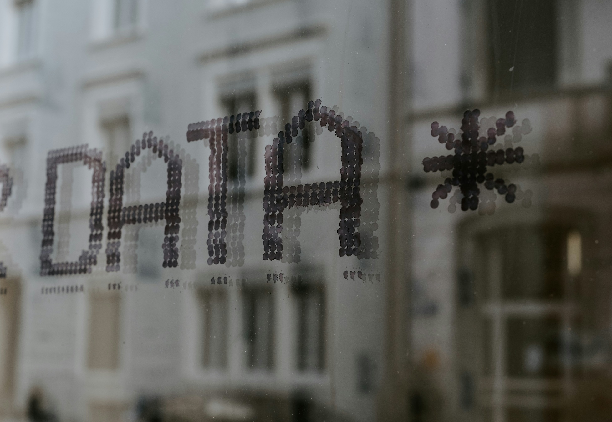 Close up of window with Data written on it and a building reflection in the background; image by Claudio Schwarz, via Unsplash.com.