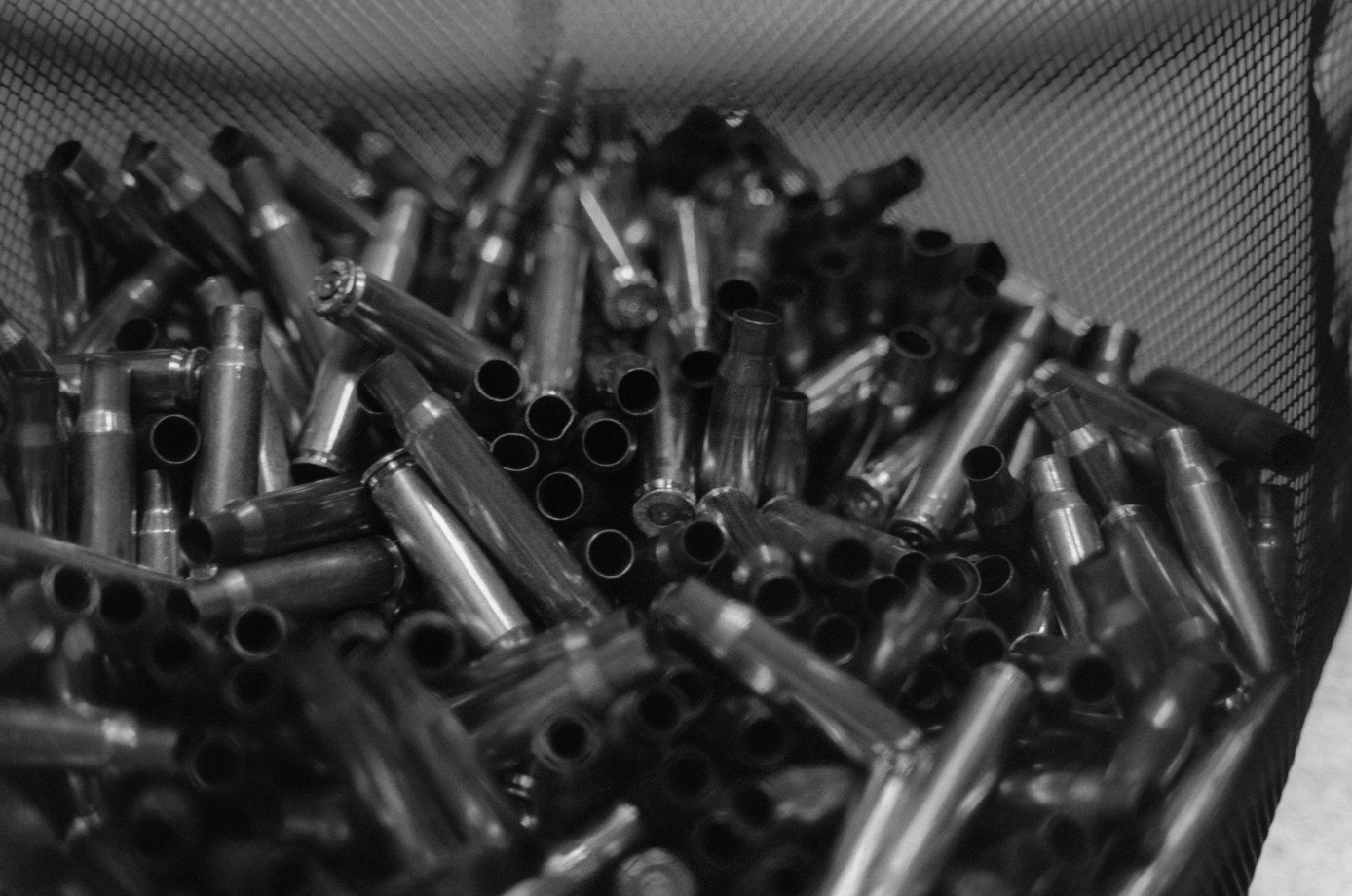 Grayscale image of empty shell casings in a mesh bag; image by Tima Miroshnichenko, via Pexels.com.