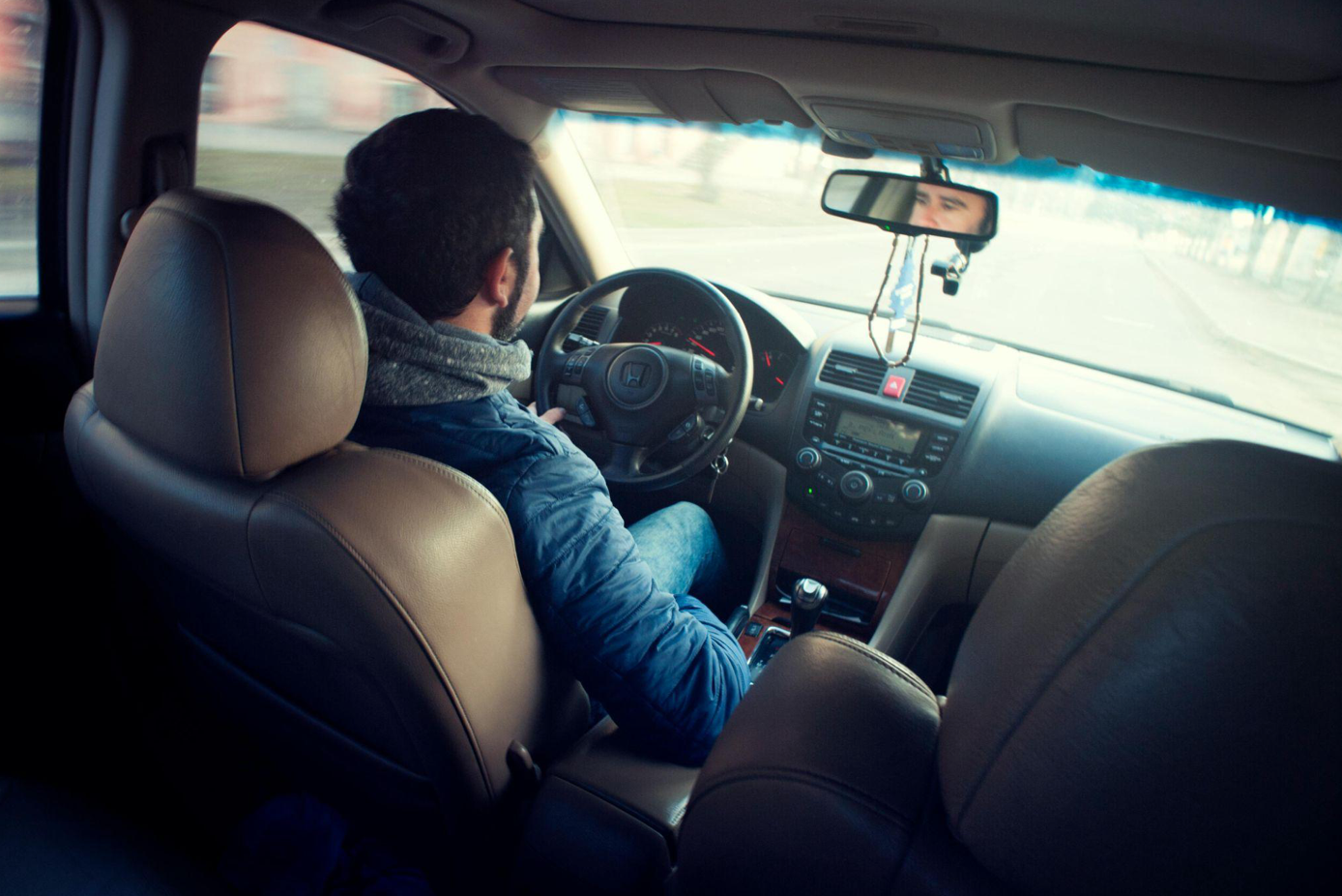 Man in blue jacket driving car; image by Oleksandr P, via Pexels.com.