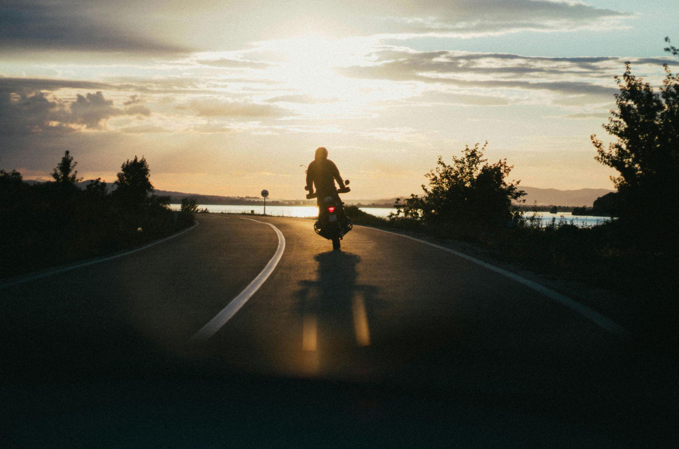 Person riding motorcycle during golden hour; image by Djordje Petrovic, via Pexels.com.