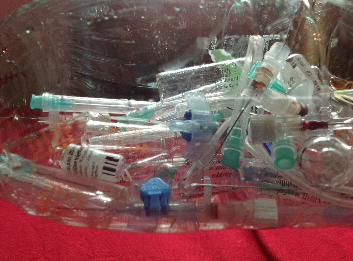 Clear bag of syringes and other medical waste; image by Alex Roma, via Pixabay.com.