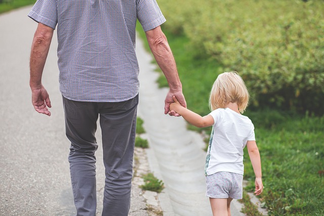 Father holding child's hand; image via Rawpixel.com, Public Domain.