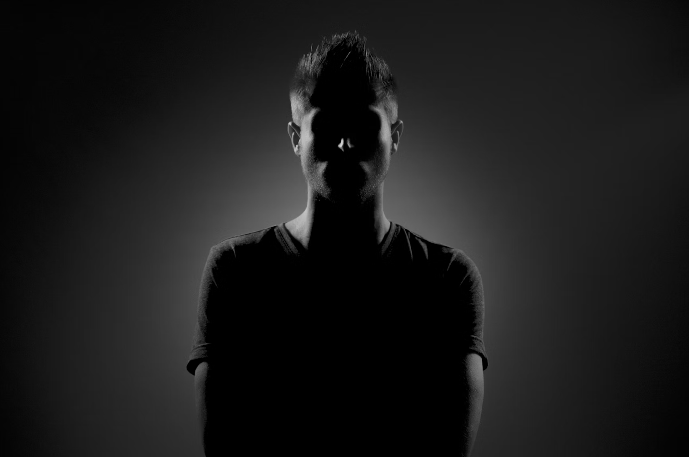 Grayscale shot of man in dark clothing; image by Arthur Chauvineau, via Unsplash.com.