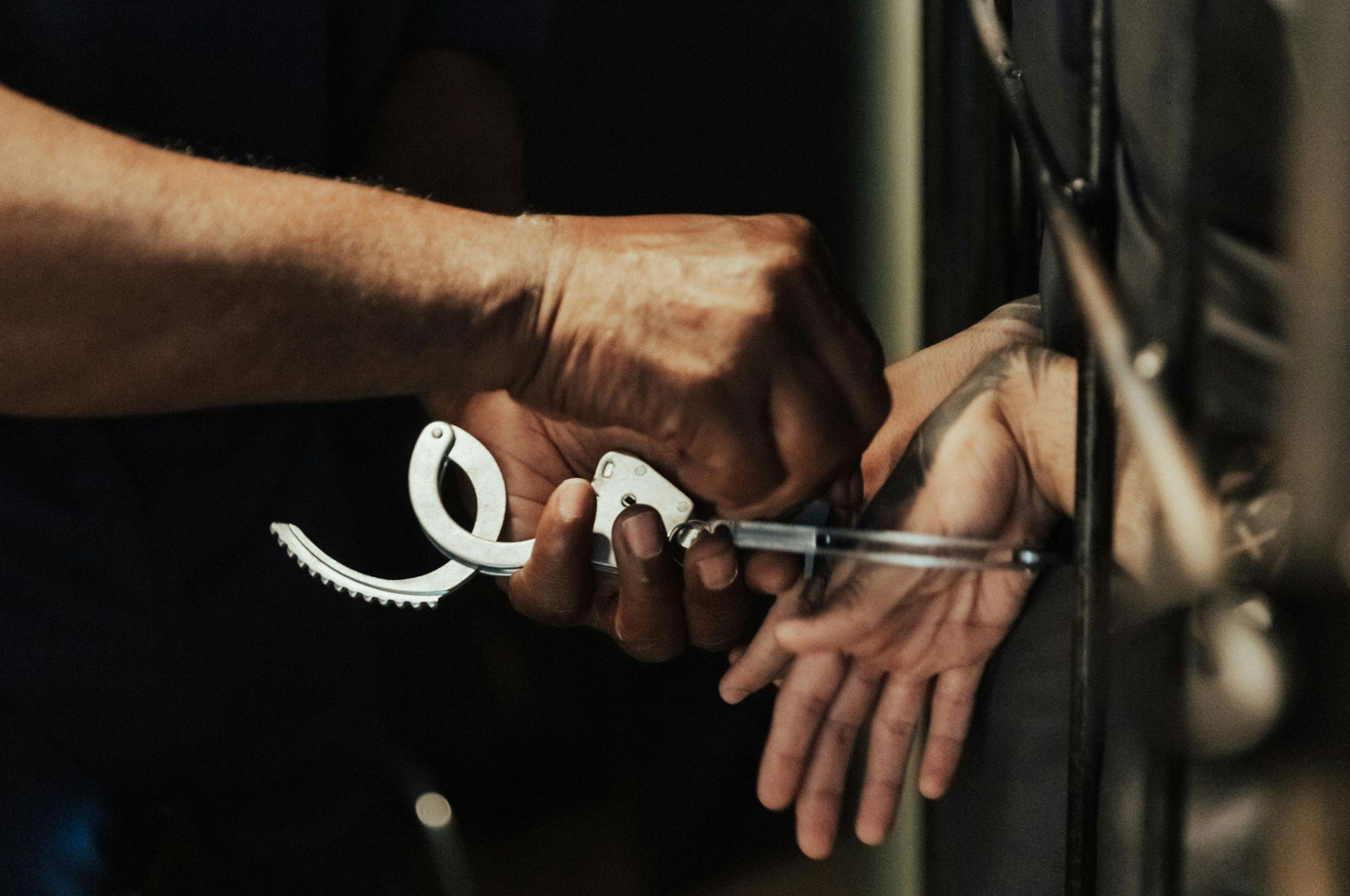 Handcuffs being taken off; image by Ron Lach, via Pexels.com.