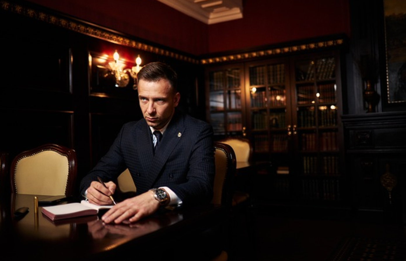 Lawyer taking notes at table in dark wood office; image by ADArt00090, via Pixabay.com.