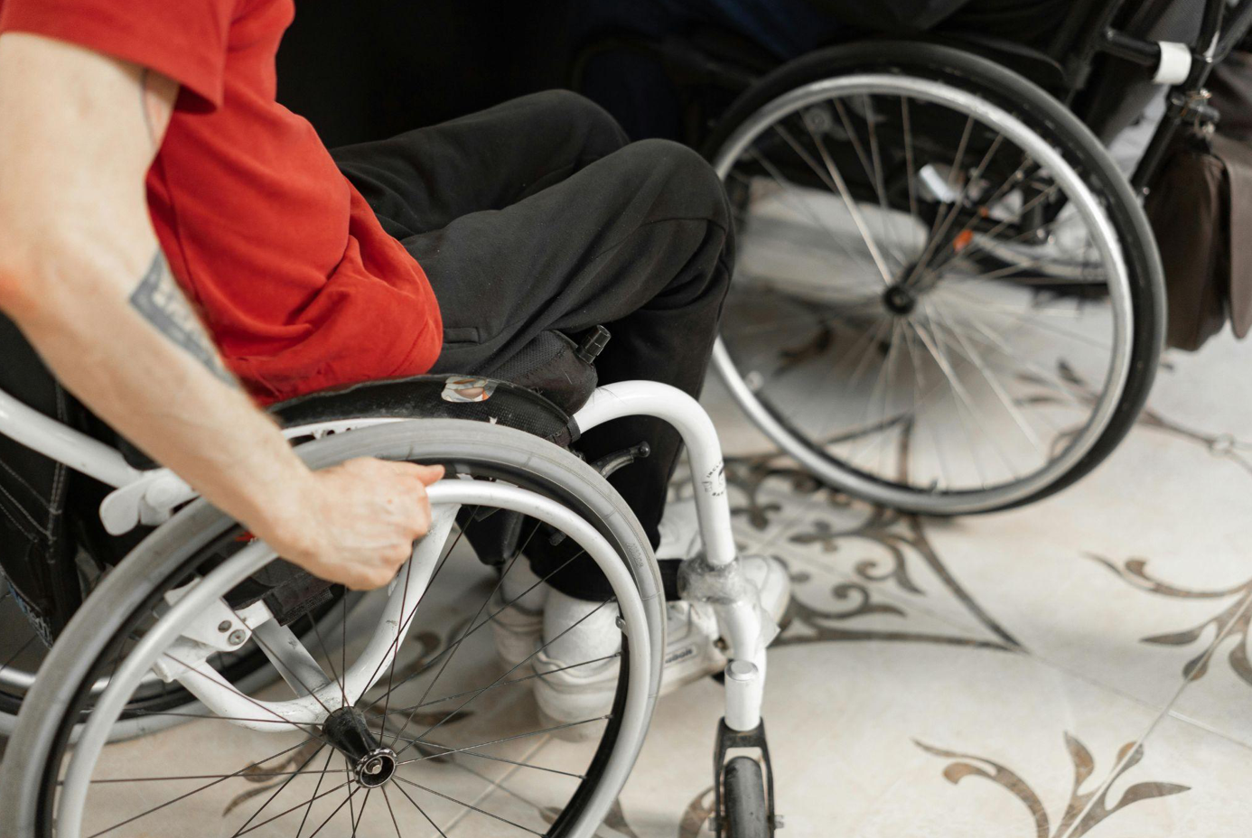 Man in wheelchair; image by Mikhail Nilov, via Pexels.com.