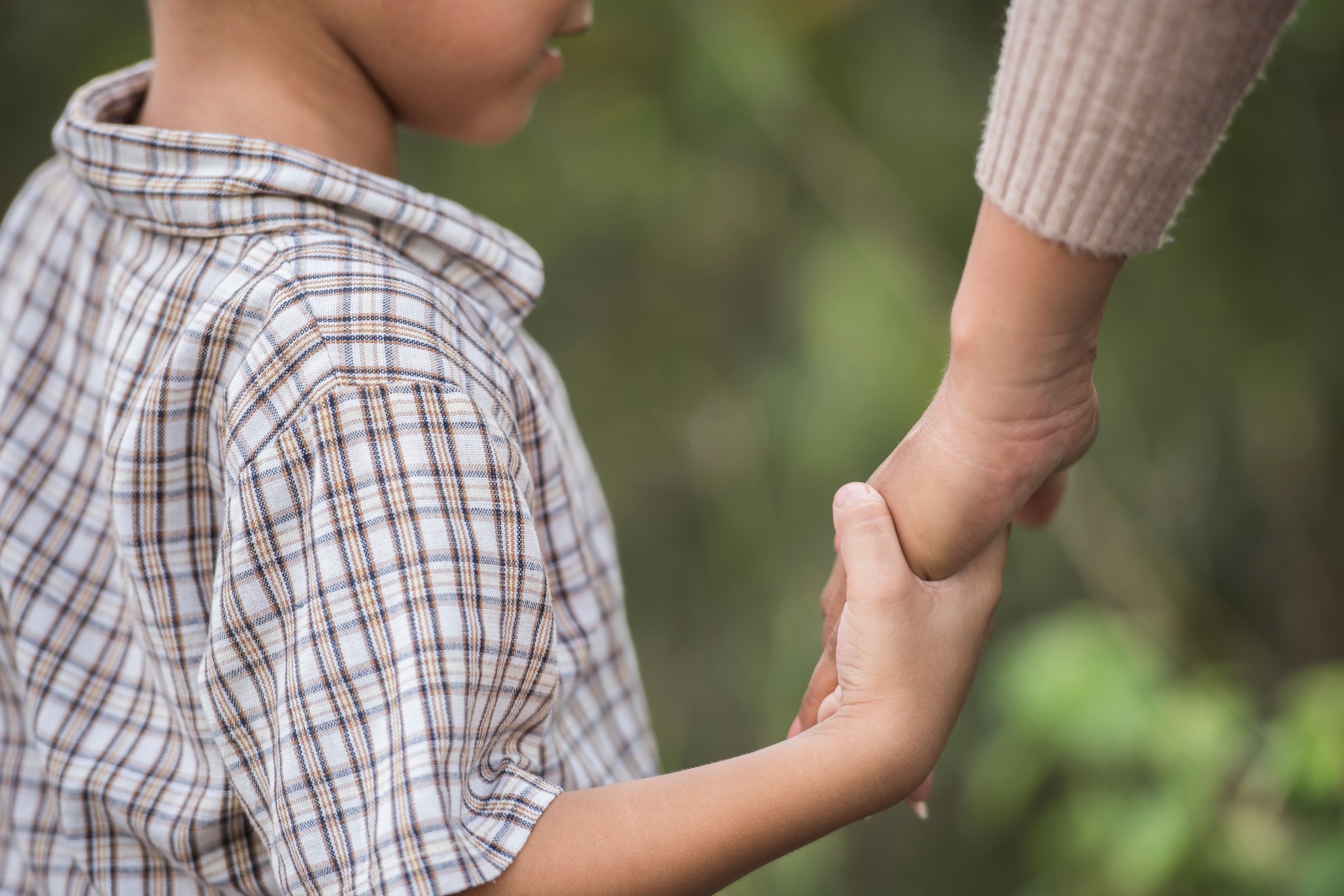 Mother and child holding hands; image by jcomp, via Freepik.com.