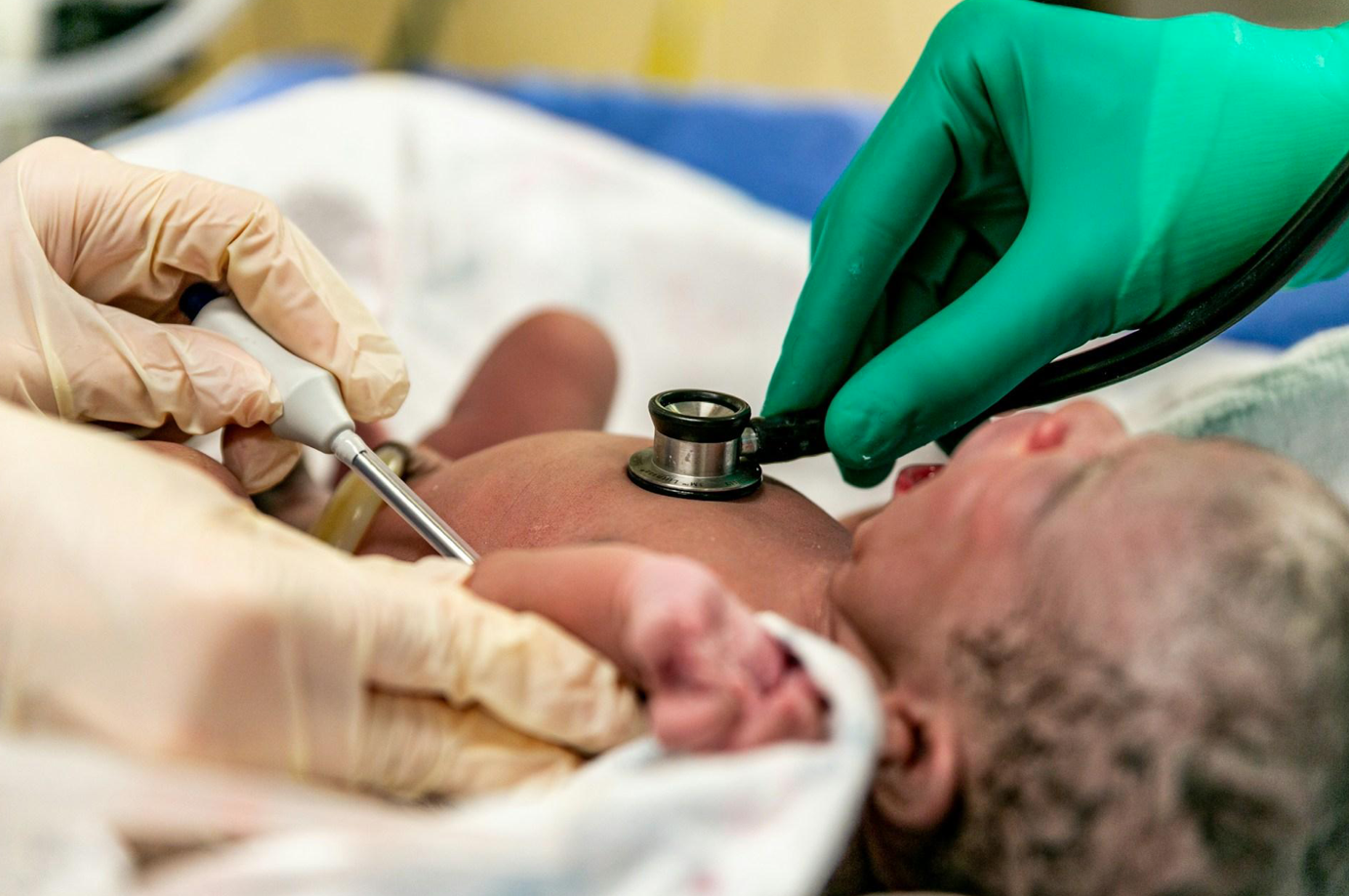 Newborn baby being examined; image by Solen Feyissa, via Unsplash.com.