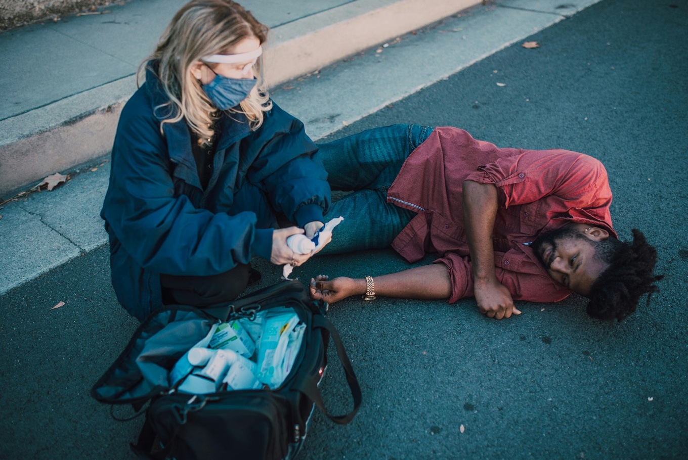 Paramedic helping man lying on the ground; image by RDNE Stock project, via Pexels.com.