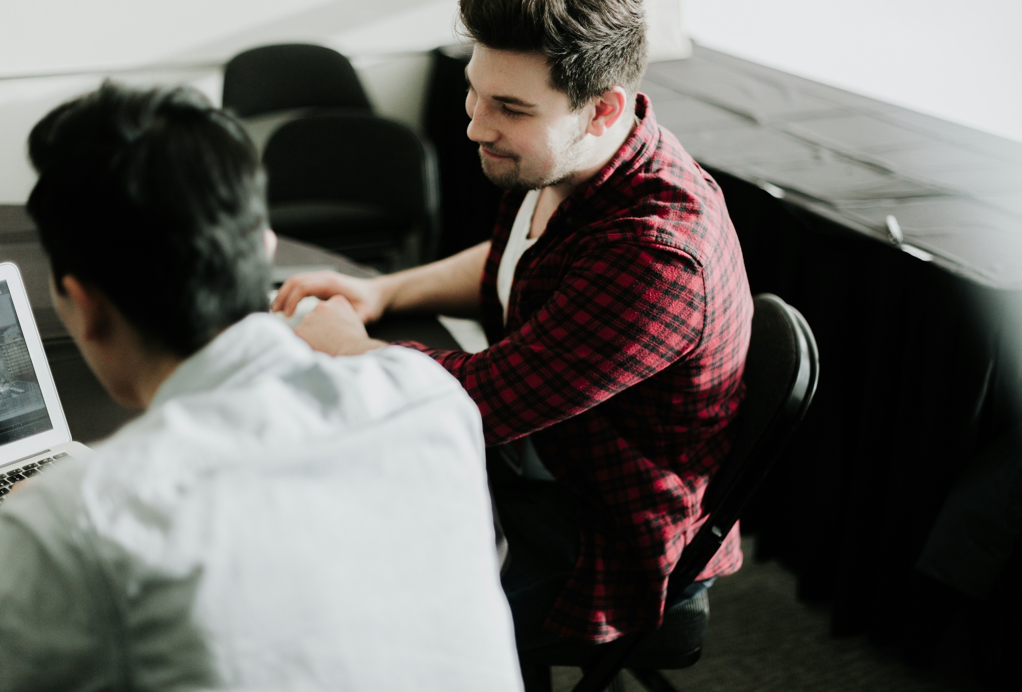 Two men at a table with a laptop; image by Priscilla Du Preez, via Unsplash.com.