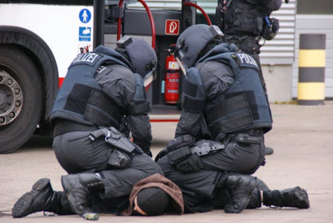 Officers stopping suspect; image by O H, via Pexels.com.