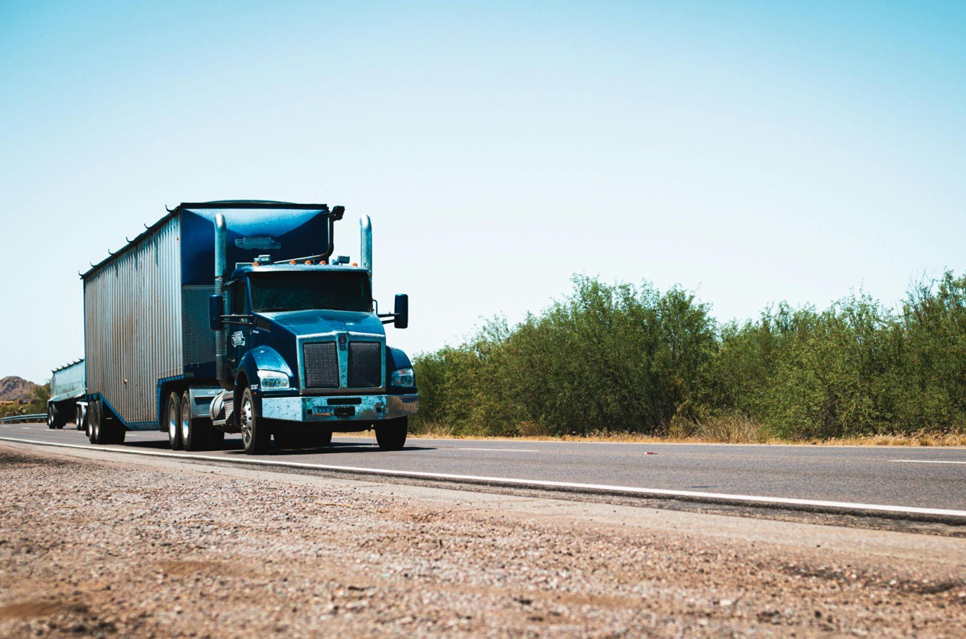 Semi-truck driving down the road; image by Tom Jackson, via Pexels.com.