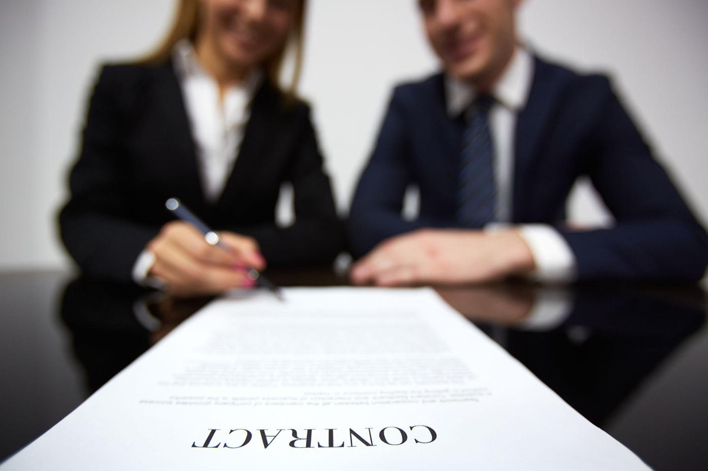 Woman signing a contract; image by pressfoto, via Freepik.com.