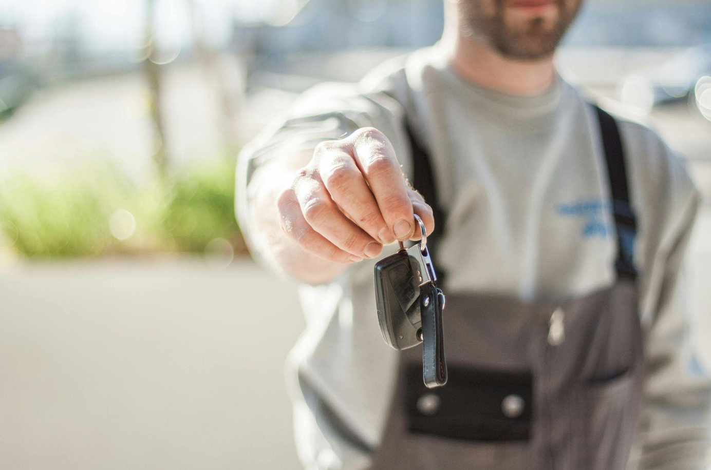 Shallow focus of car key held by man; image by Negative Space, via Pexels.com.