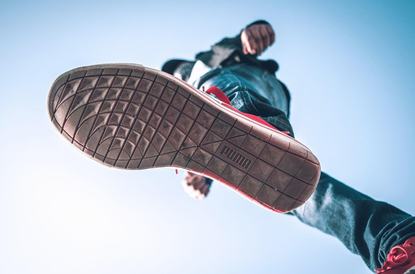 Upshot of bottom of Puma shoe worn by man walking; image by Ashutosh Sonwani, via Pexels.com.