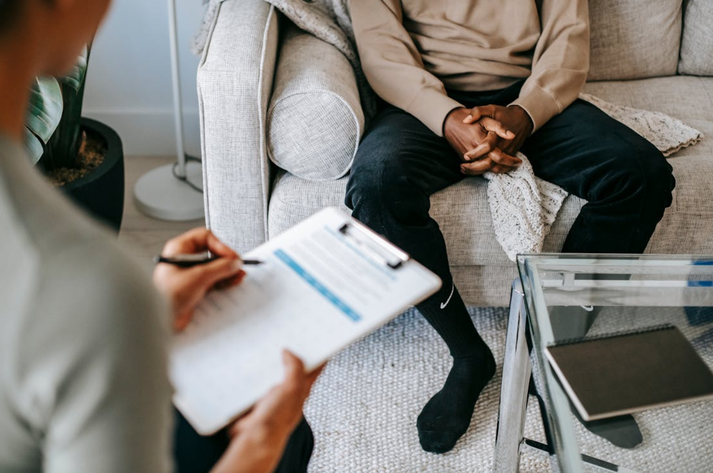 Crop ethnic client discussing problems with anonymous psychologist; image by Alex Green, via Pexels.com.